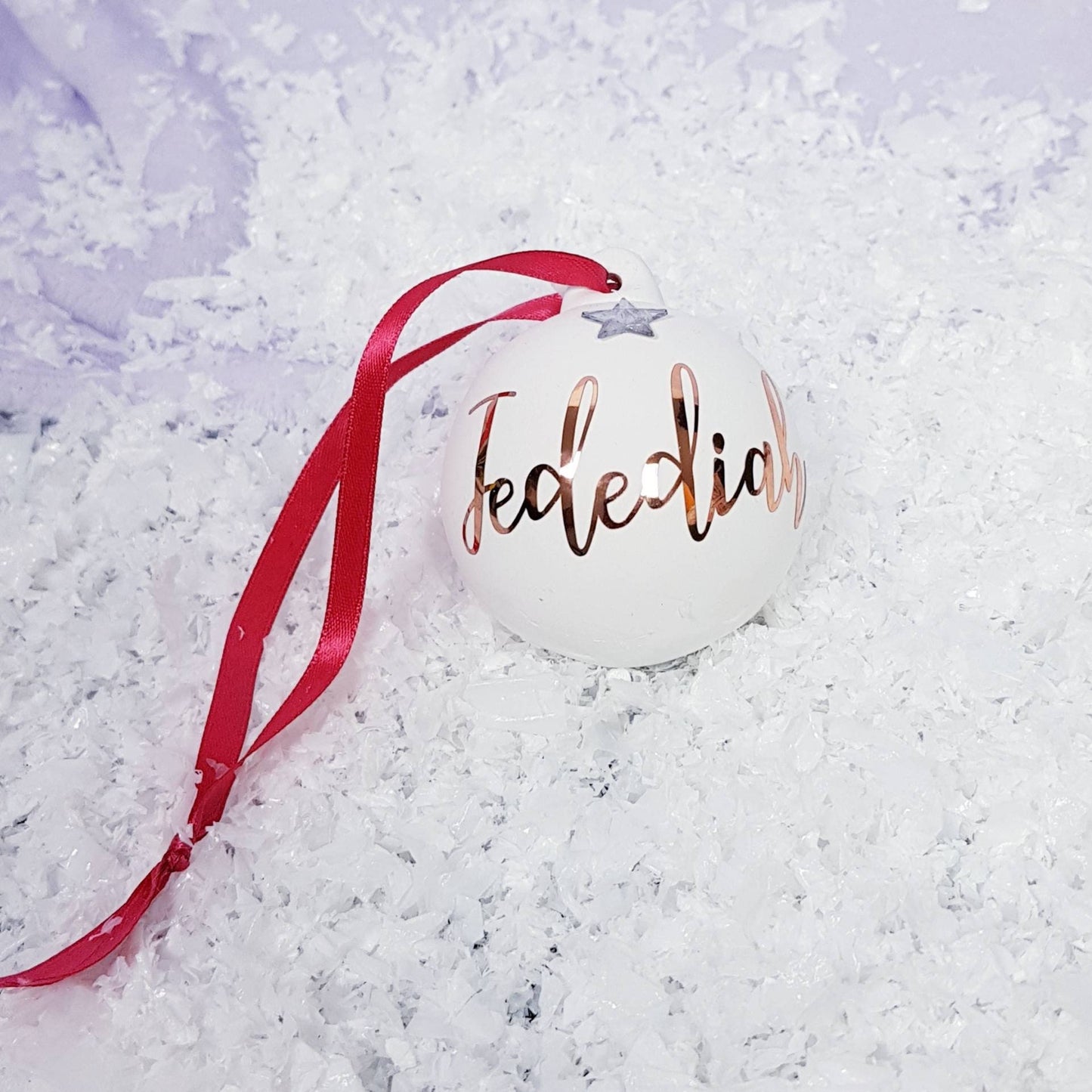 Close-up of personalised name and frosted star detail on ceramic Christmas tree bauble