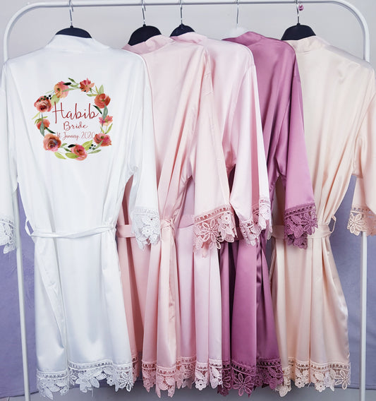 Personalised satin bridal robes hanging together showing range of colour options for bridal party
