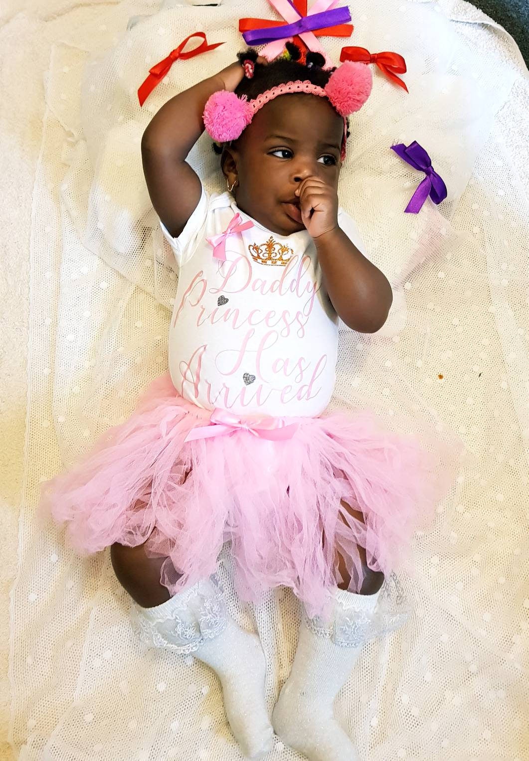 Close-up of Daddy's Princess Has Arrived bodysuit showing satin bow and text detail on white cotton fabric