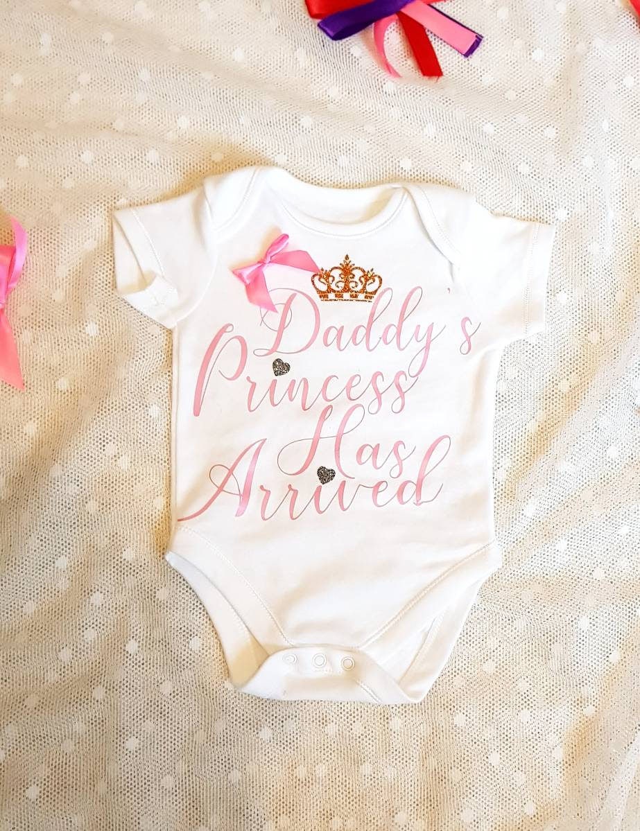 Daddy's Princess Has Arrived white newborn baby bodysuit with pink satin bow detail and vinyl lettering