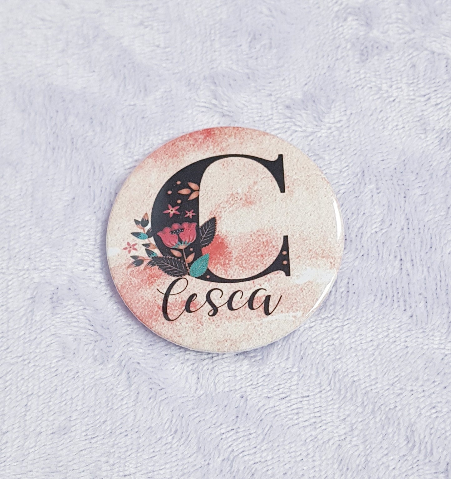Close-up of personalised initial design on compact pocket mirror, 5.8cm diameter