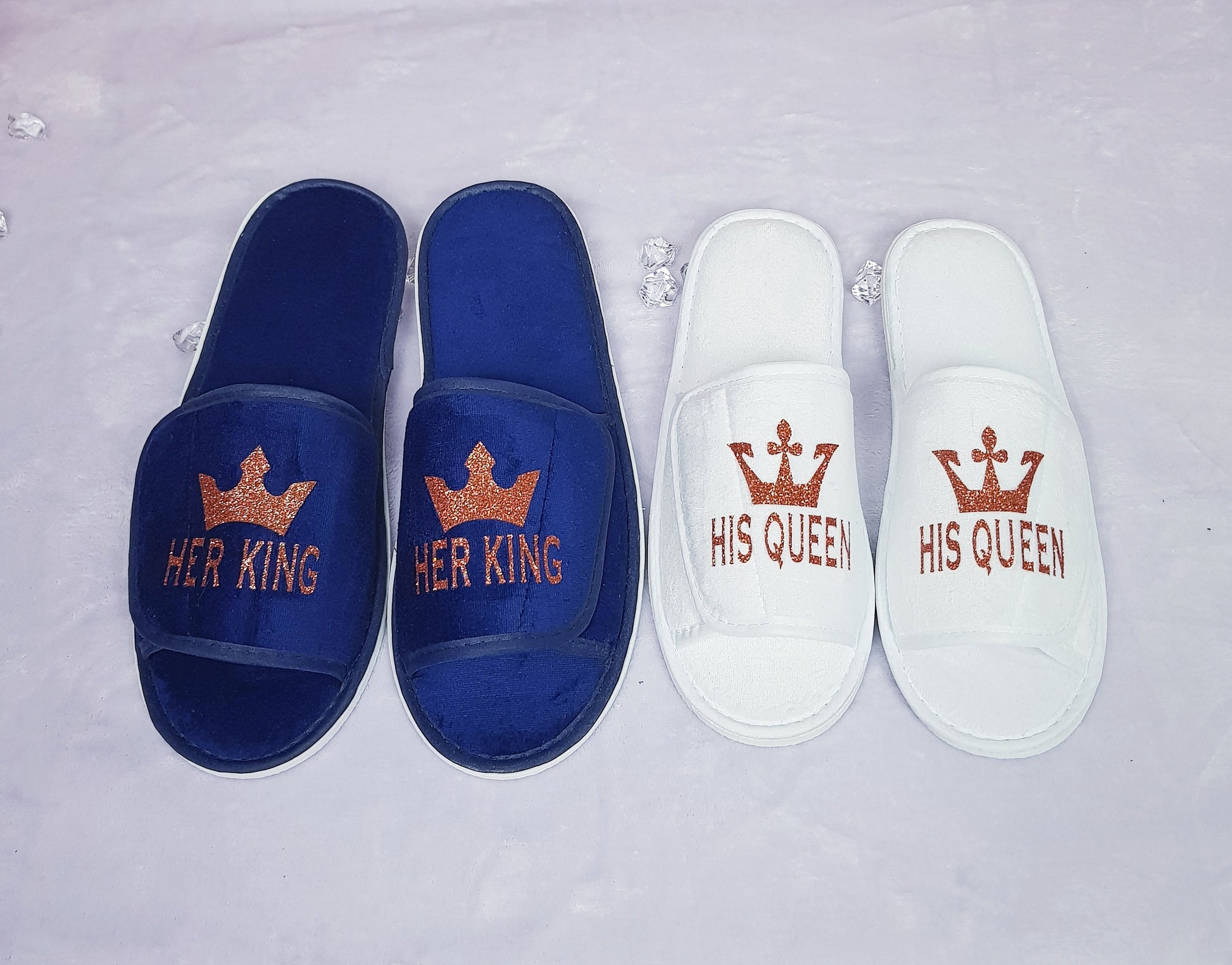 Close-up of His Queen white spa slipper with gold crown design and text
