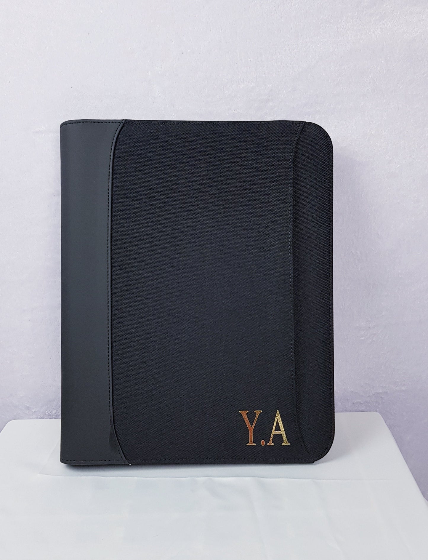 Close-up of gold foil monogram personalisation detail on portfolio organiser cover