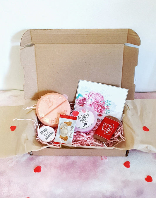 Spa pamper letterbox gift box contents including shower mixer, wax melt, card, pin badge and treats