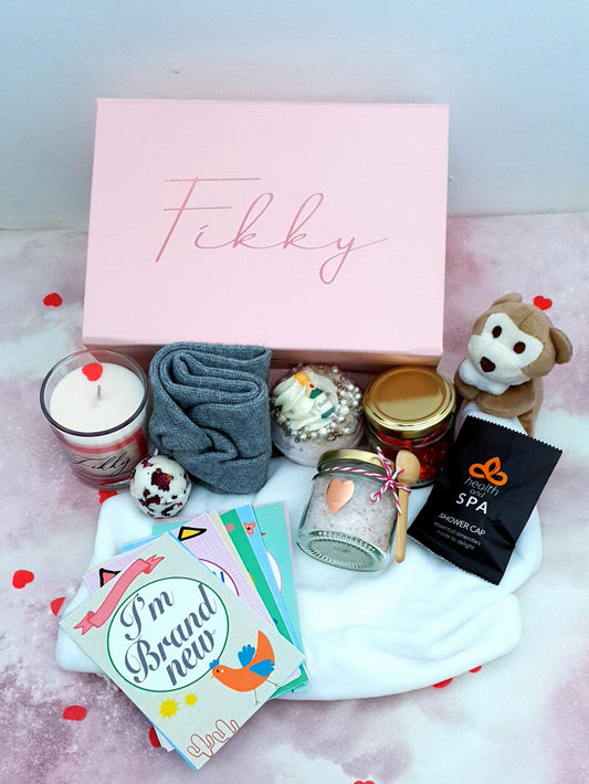 Contents of luxury new mum gift box showing personalised candle, bath products and baby items