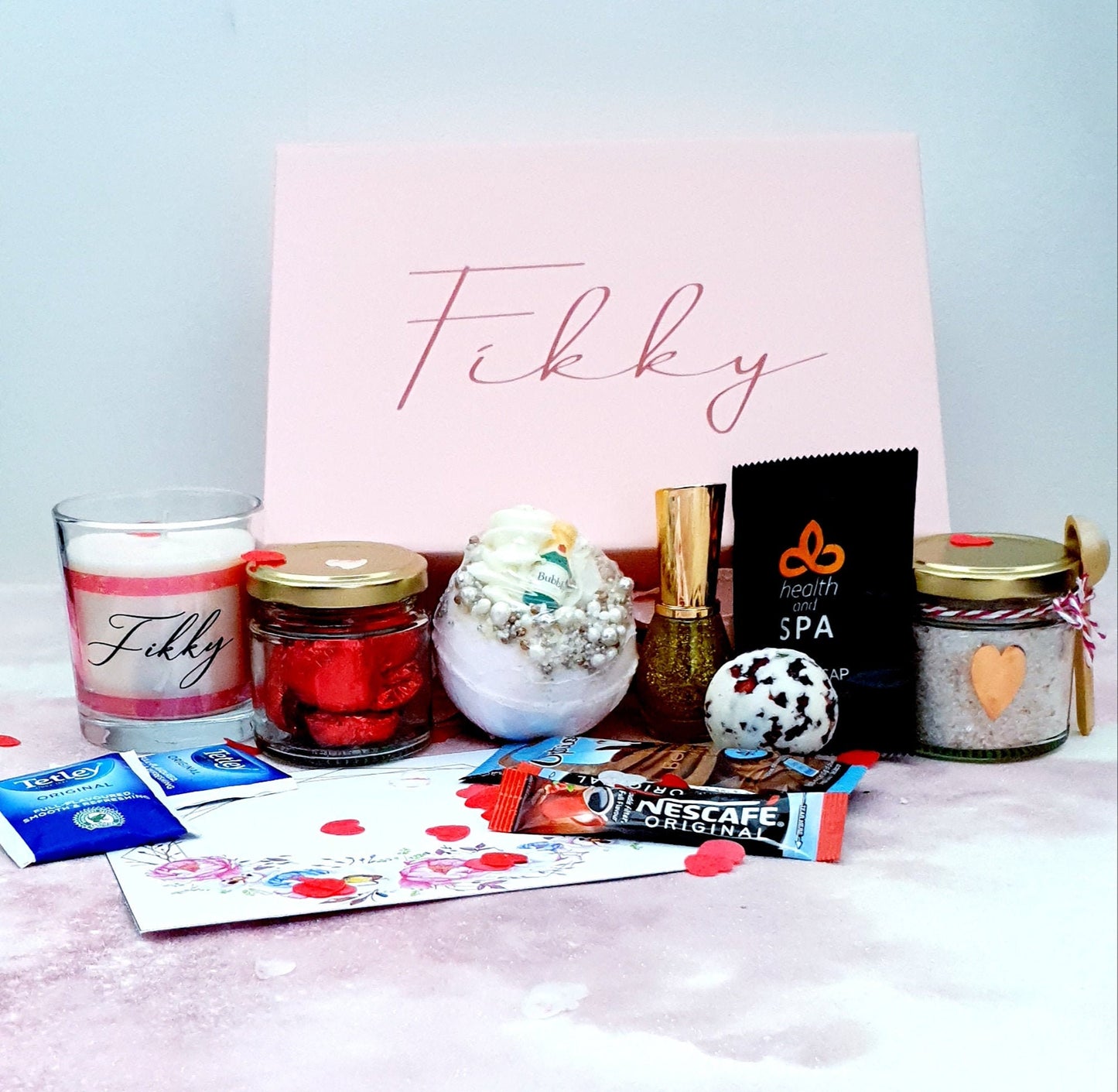 Contents of personalised pamper gift box showing candle, nail polish, tea and hot chocolate