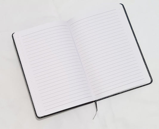 Personalised black A5 lined notebook showing vegan leather cover and personalisation detail
