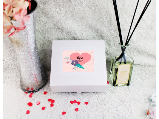 Contents of personalised birthday gift box showing rose gold purse, mirror, hand cream and treats