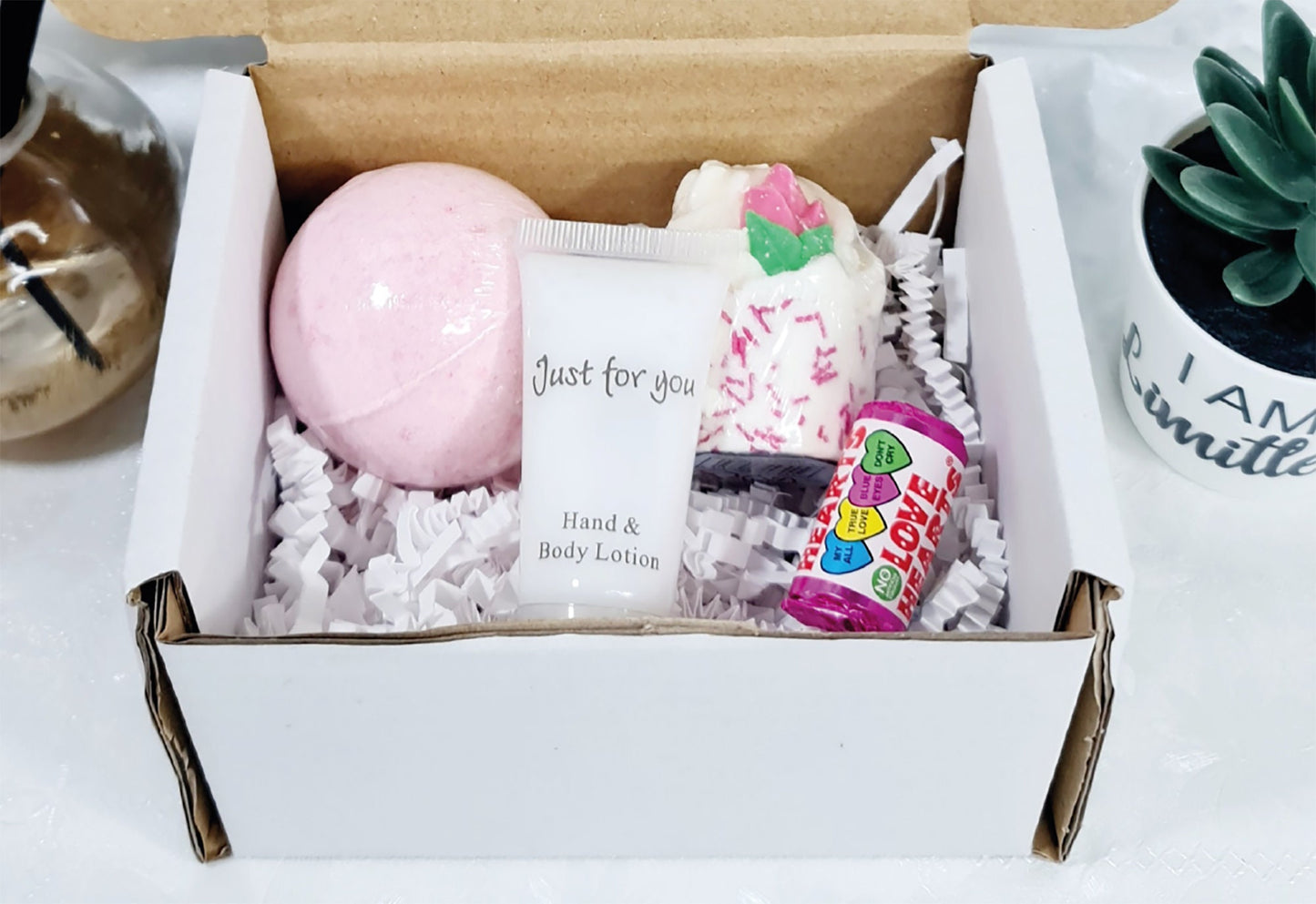 Contents of graduation gift box showing bath bomb, bath melt, hand cream and sweet